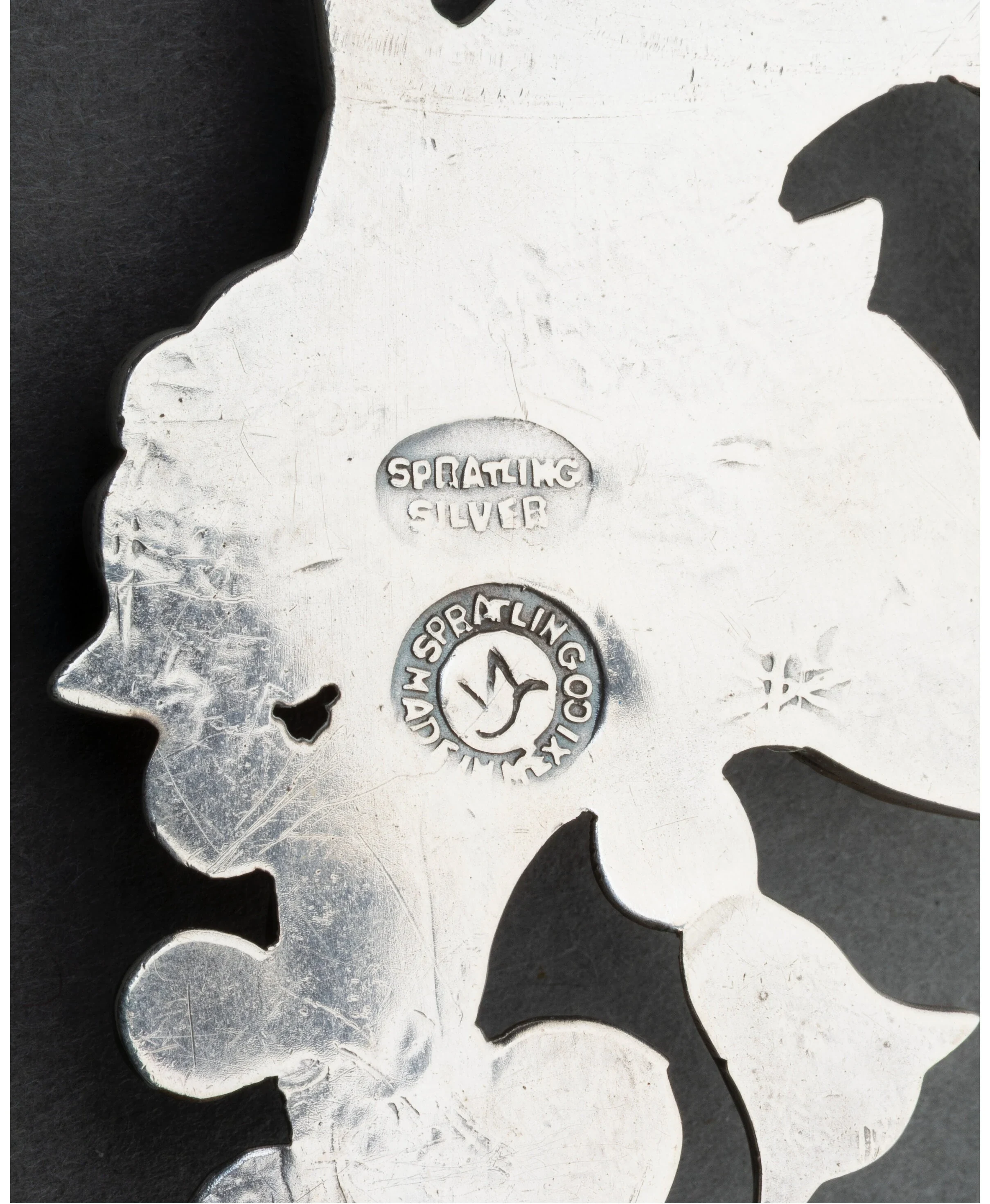 William Spratling's circa-1940 hallmarks on the reverse of the Tree of Life brooch: an oval SPRATLING SILVER stamp above the circular WS bird cartouche ringed WM SPRATLING MADE IN MEXICO.